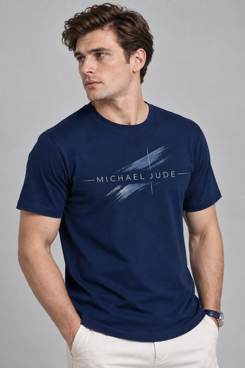 Model wearing a Michael Jude navy blue crewneck t-shirt with a white artistic brushstroke graphic on the chest.